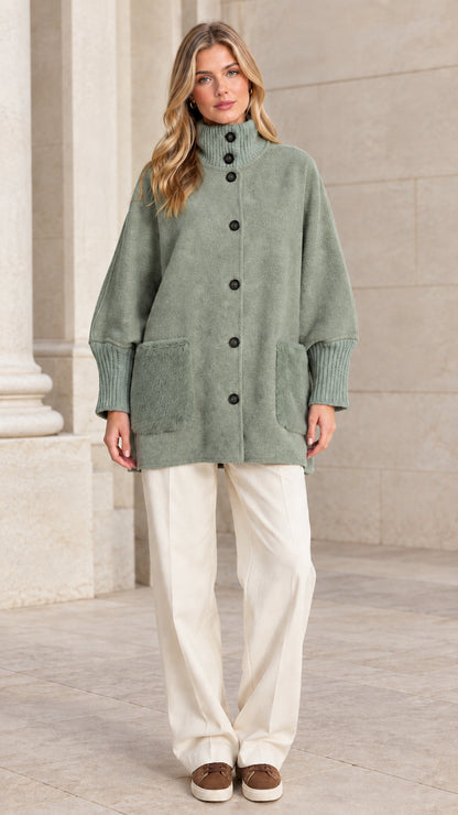 Full front view of a woman wearing a sage green mock neck button-down jacket