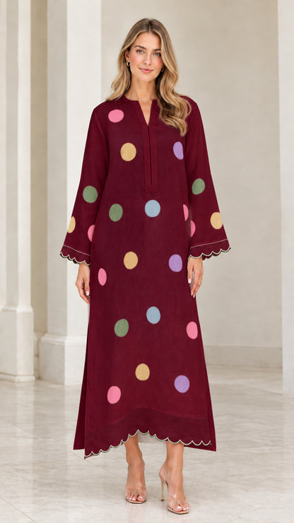 Woman wearing deep burgundy polka dot long sleeve maxi kaftan dress