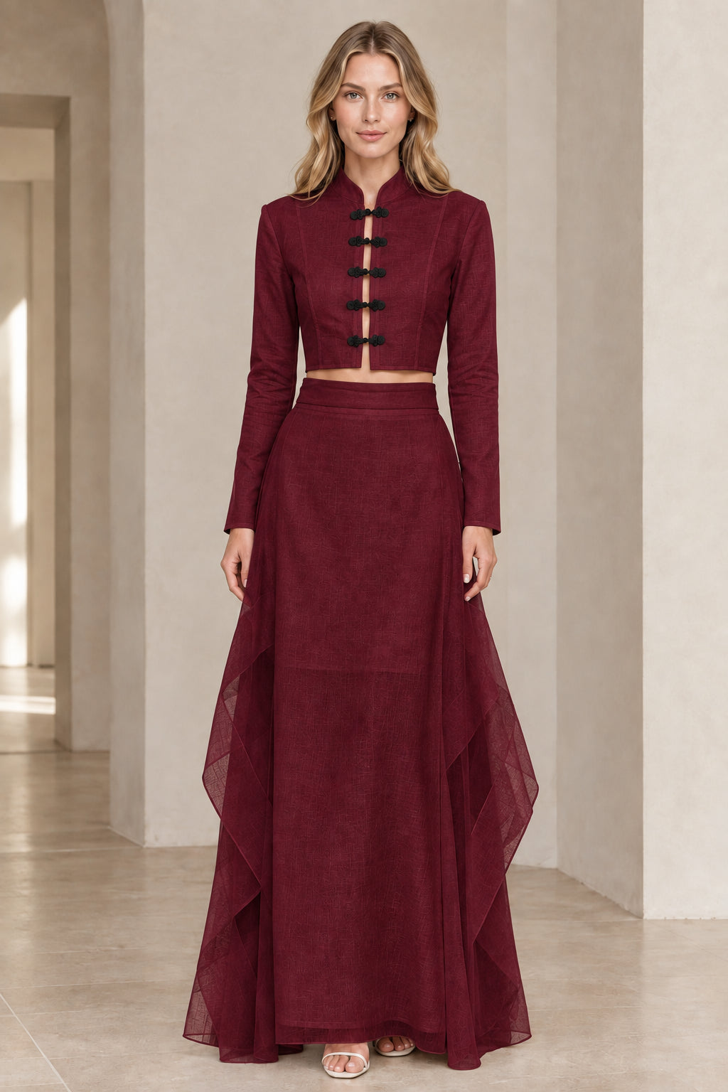 Front view of model wearing burgundy wine red frog button crop top and maxi skirt set