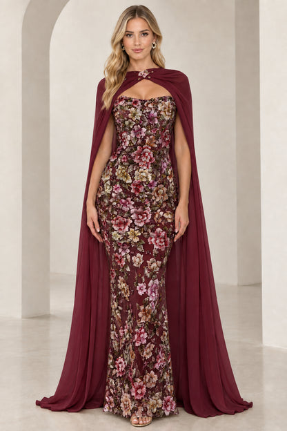 Model wearing rich burgundy wine floral embroidered evening gown with flowing cape