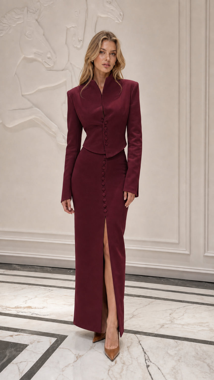 Model wearing burgundy formal two-piece jacket and skirt set