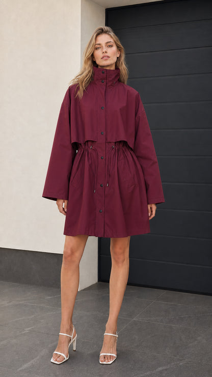 Front full-length view of woman wearing burgundy drawstring parka coat