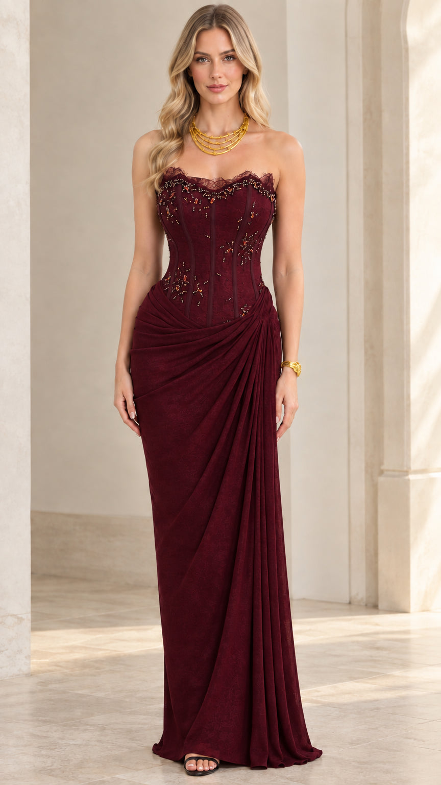 Model wearing burgundy red strapless corset draped maxi dress