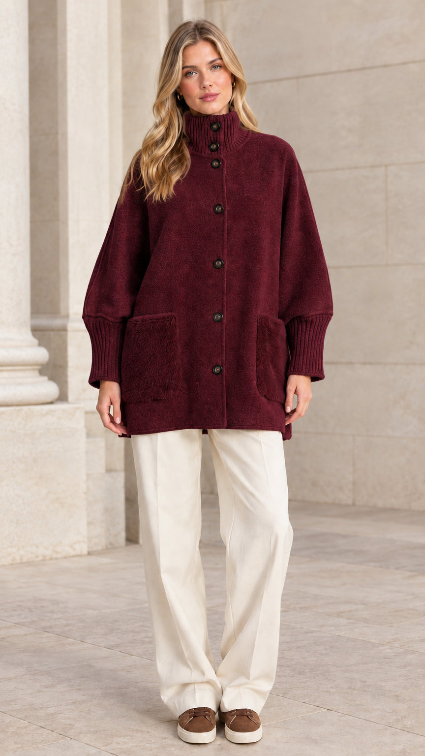 Full front view of a woman wearing a burgundy red mock neck button-down jacket