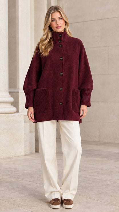 Full front view of a woman wearing a burgundy red mock neck button-down jacket