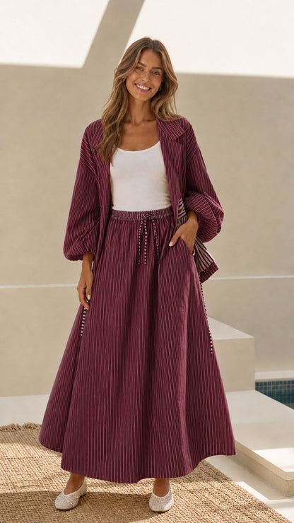 Model wearing burgundy wine striped open-front jacket and maxi skirt set