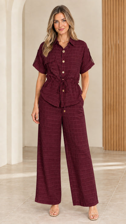 Full front view of model wearing burgundy textured button-up top and wide leg pants set