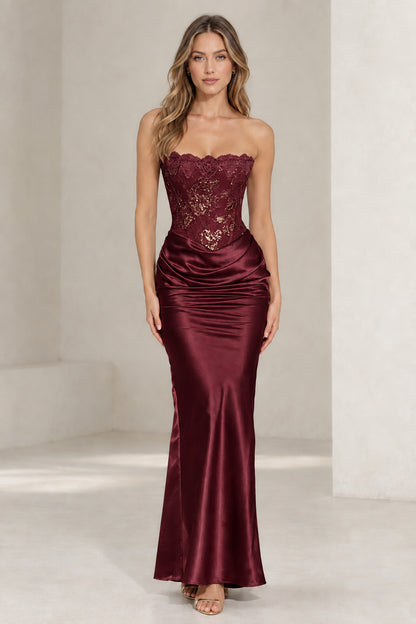 Front view of woman wearing burgundy strapless lace corset satin maxi dress