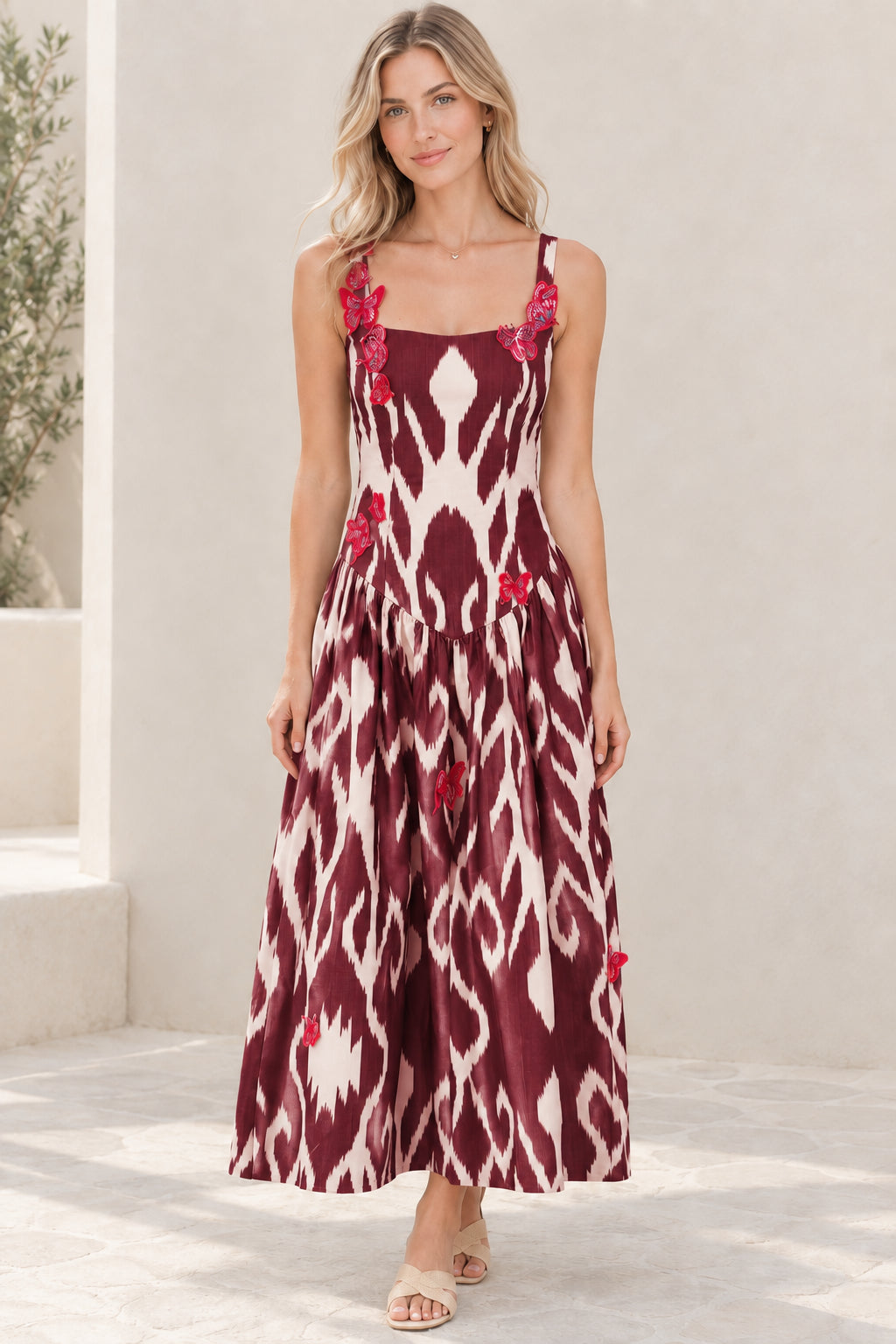 Model wearing burgundy wine red ikat print maxi dress with pink butterfly accents