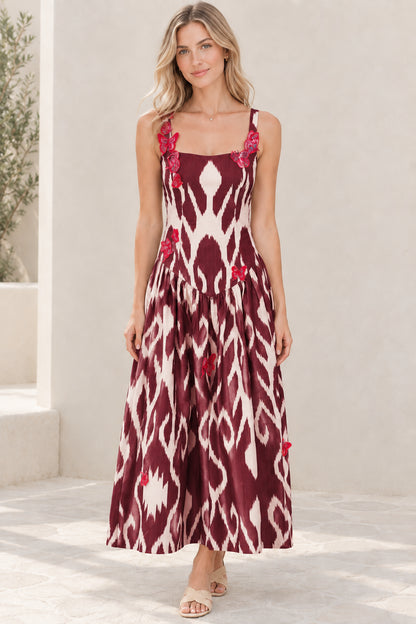 Model wearing burgundy wine red ikat print maxi dress with pink butterfly accents