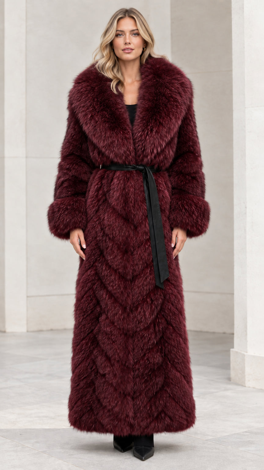 Front view of burgundy red chevron faux fur maxi coat with tie belt