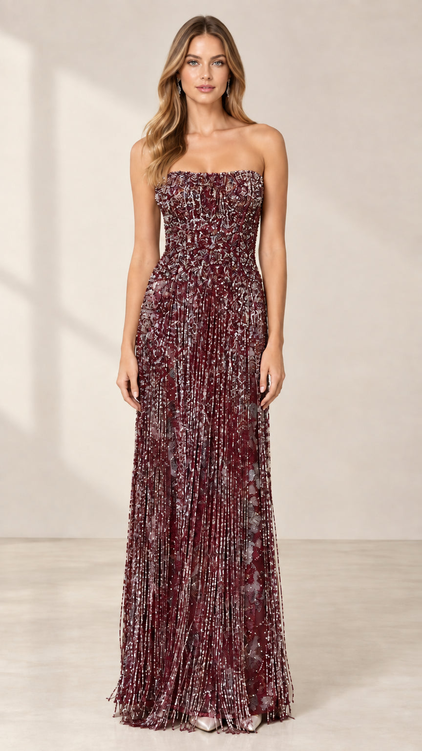 Front view of model wearing burgundy strapless beaded fringe evening gown