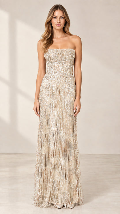 Front view of model wearing champagne strapless beaded fringe evening gown