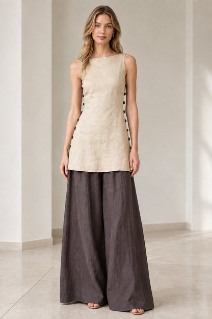 Model wearing natural beige sleeveless tunic top paired with charcoal wide-leg pants
