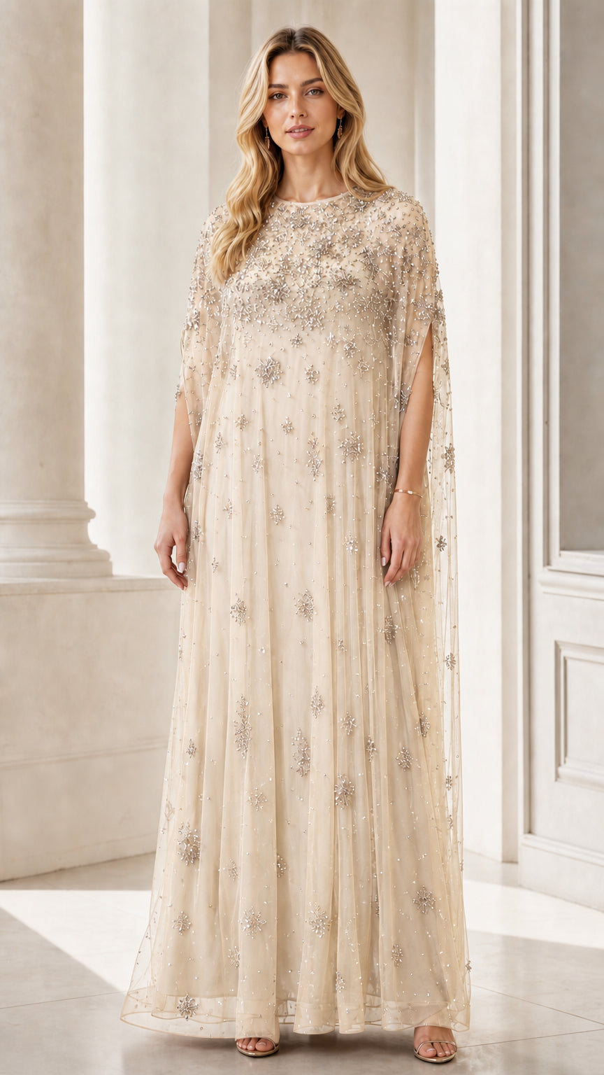 Front view of champagne beaded mesh cape maxi dress