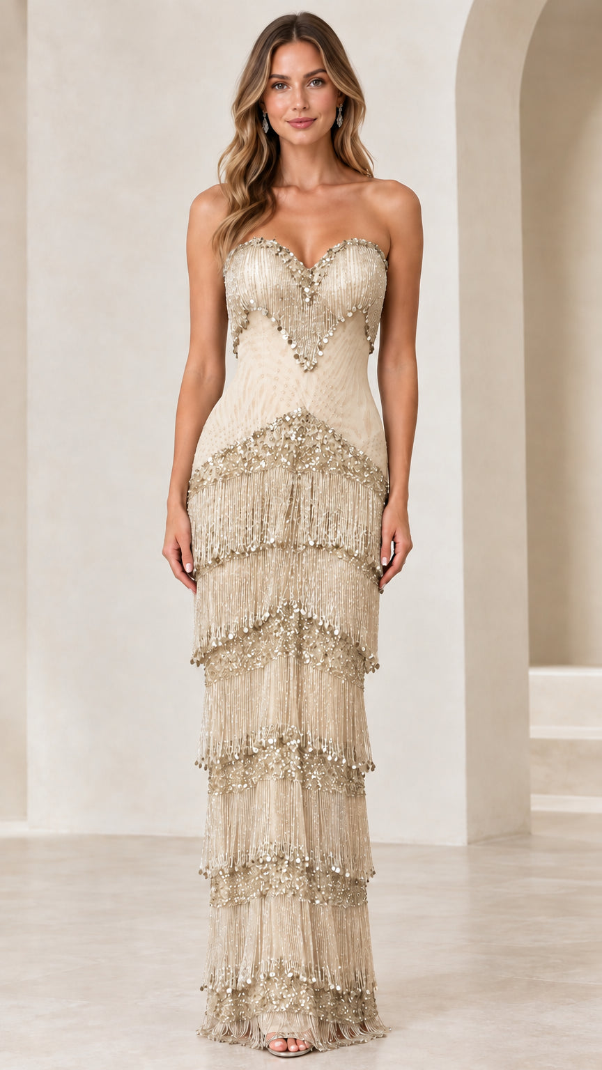 Front view of woman wearing champagne gold strapless beaded fringe evening gown